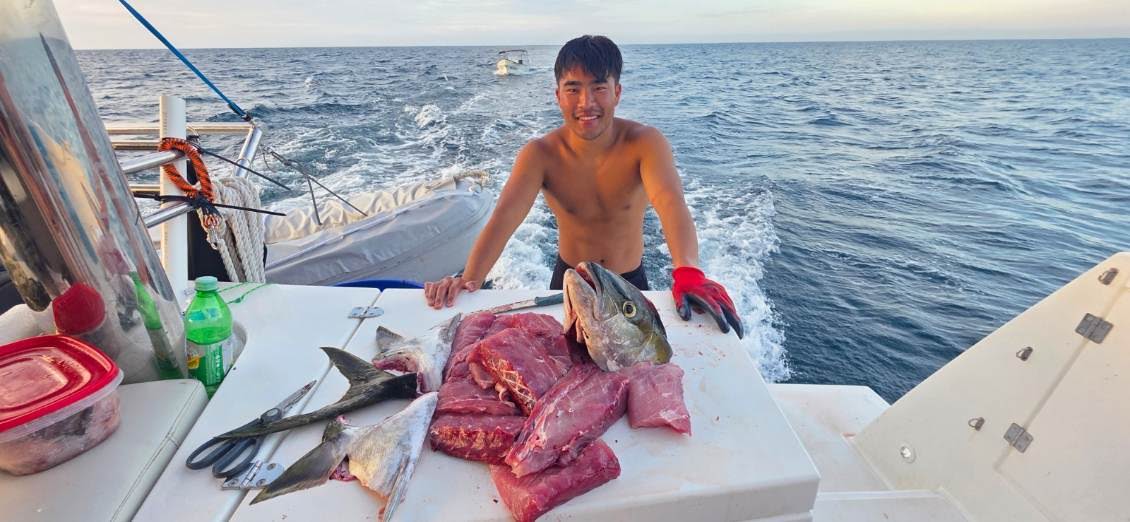 Preparing a fresh catch on the stern of a boat